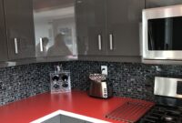 Beautiful kitchen with glossy grey cabinets and red counter top